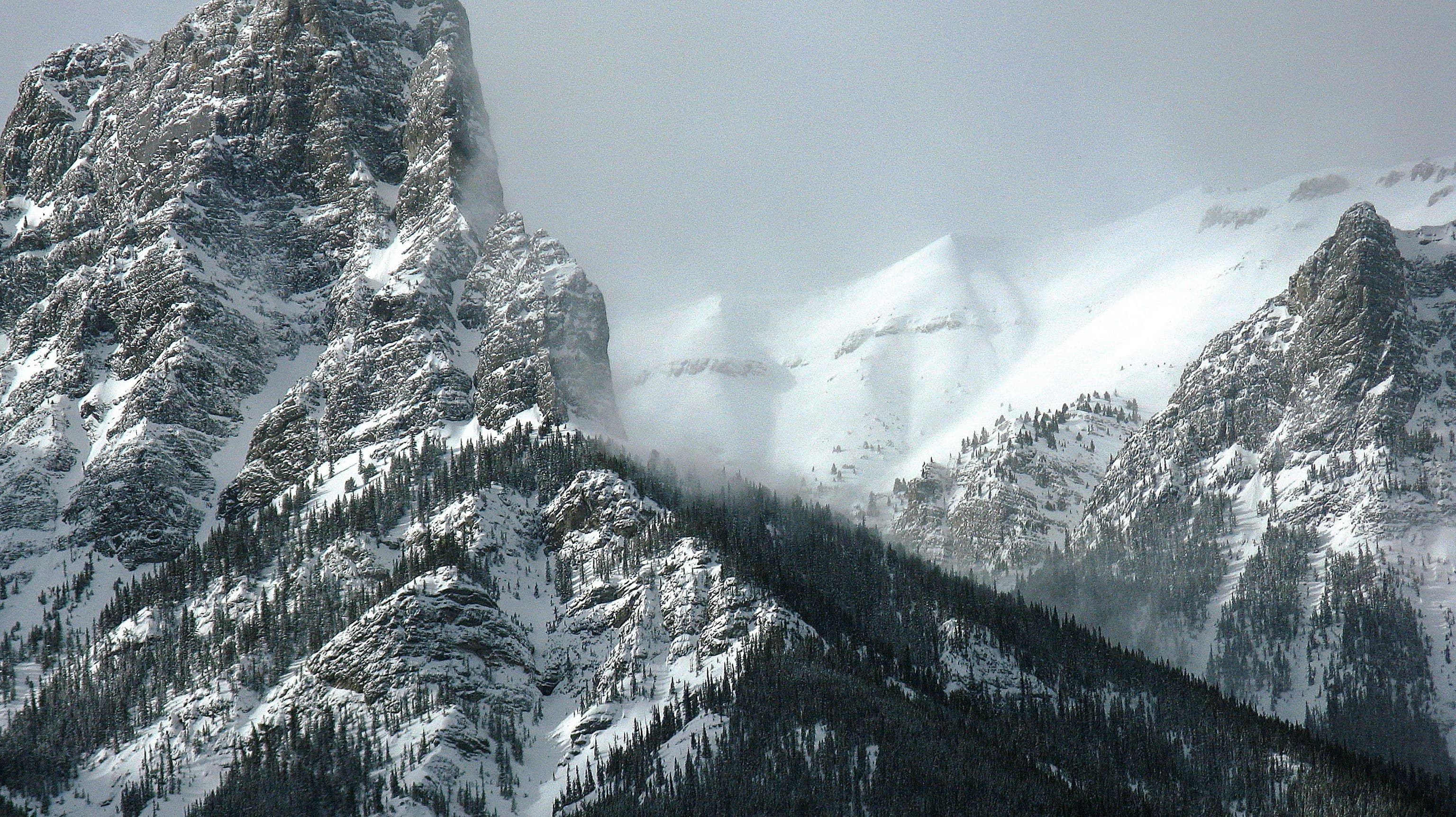 Fog over tall snowy mountains